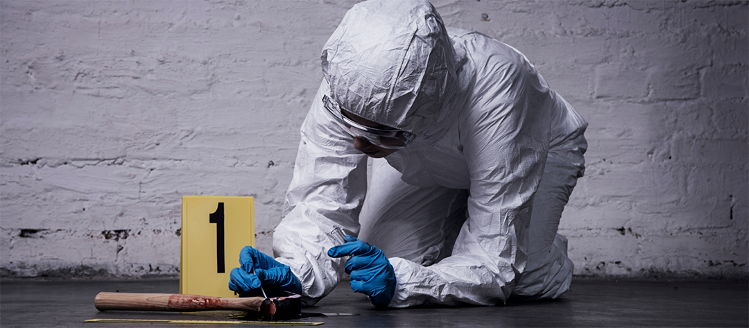 crime scene investigator in full PPE swabbing blood from a hammer