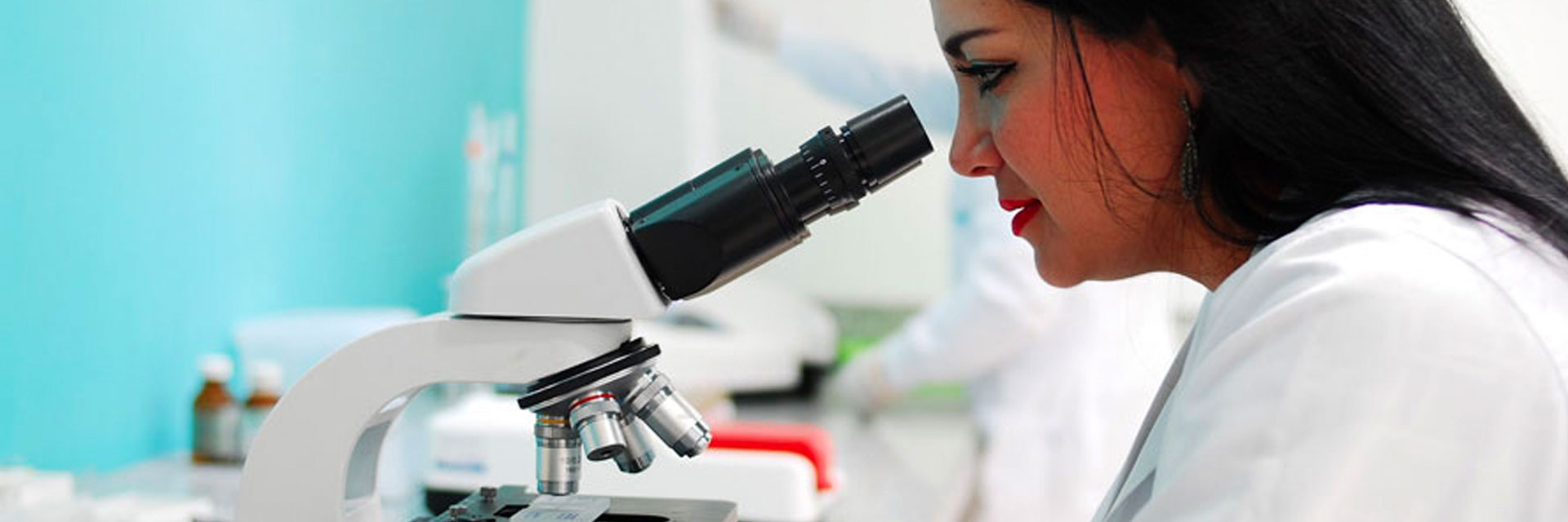 scientist looking through microscope